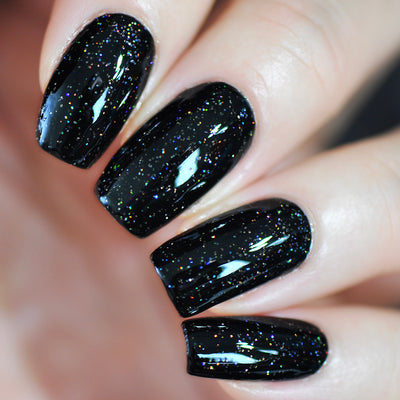 Neutrino by Starrily, jet black base densely scattered with fine silver holographic glitter catching spectral highlights, on a light skin tone hand