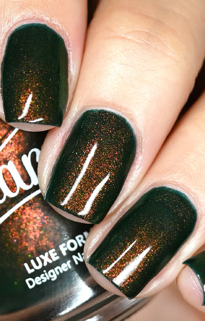 Artemis by Starrily, forest green multichrome shimmer with copper-orange shift in bright daylight, glossy topcoat applied, on a light skin tone hand