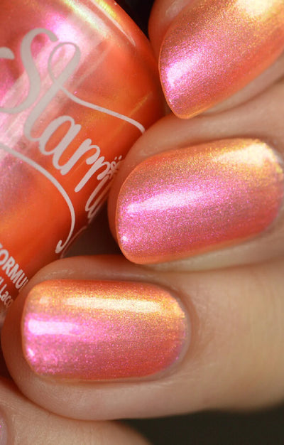 Moon Sugar by Starrily, warm coral-orange shimmer showing hot pink to golden-yellow iridescent shift alongside the bottle, on a light skin tone hand