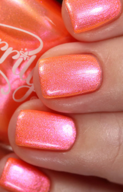 Moon Sugar by Starrily, coral-orange multichrome shimmer showing pink-to-orange shift with iridescent golden microflakes in bright daylight, on a light skin tone hand