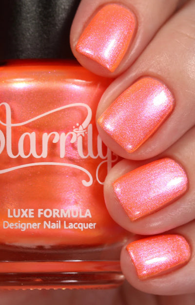 Moon Sugar by Starrily, coral-orange base with peachy-pink shimmer shift and golden iridescent micro-particles under studio lighting, on a light skin tone hand