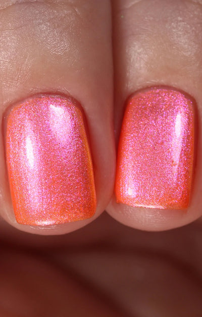 Moon Sugar by Starrily, vivid orange-red base with intense hot pink to magenta color-shifting iridescent micro-shimmer, on a light-medium skin tone hand