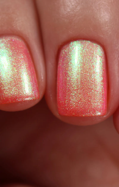 Nectar by Starrily, coral-pink multichrome shimmer blazing chartreuse at highlight zones with gold-to-green shift, on a light skin tone hand