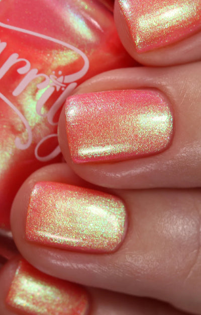 Nectar by Starrily, coral-pink multichrome shimmer with bold yellow-green shift and warm gold iridescence, on a light skin tone hand