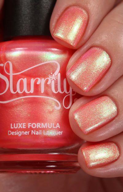 Nectar by Starrily, coral-pink multichrome shimmer showing strong pink-to-green duochrome shift, on a light skin tone hand