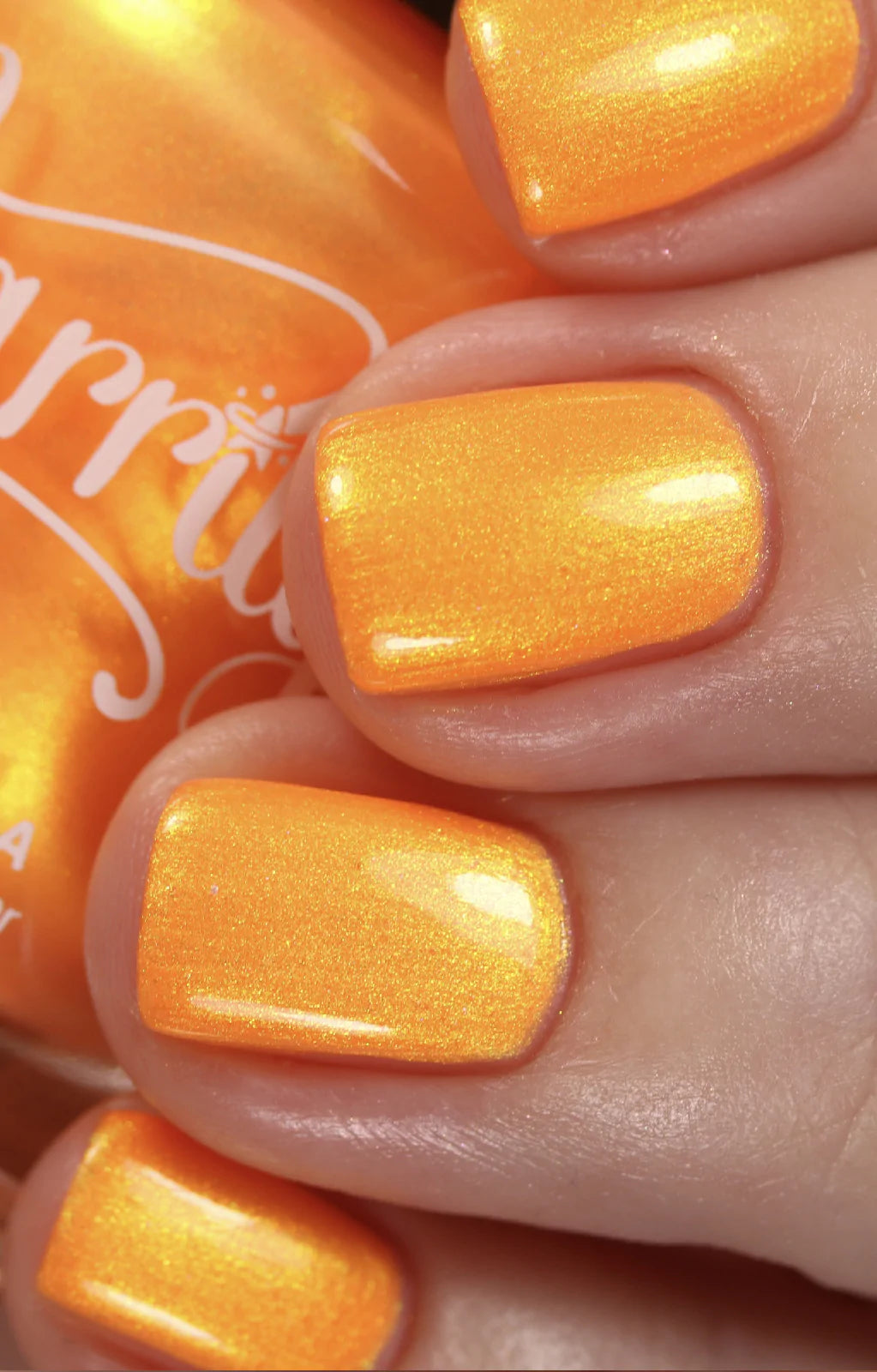 Peach Glow by Starrily, vivid orange base with intensified golden shimmer shift in bright daylight, on a light skin tone hand