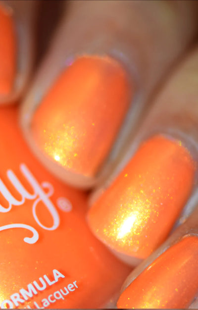 Peach Glow by Starrily, vivid orange base with blazing gold shimmer flash under direct flash lighting, on a light-medium skin tone hand