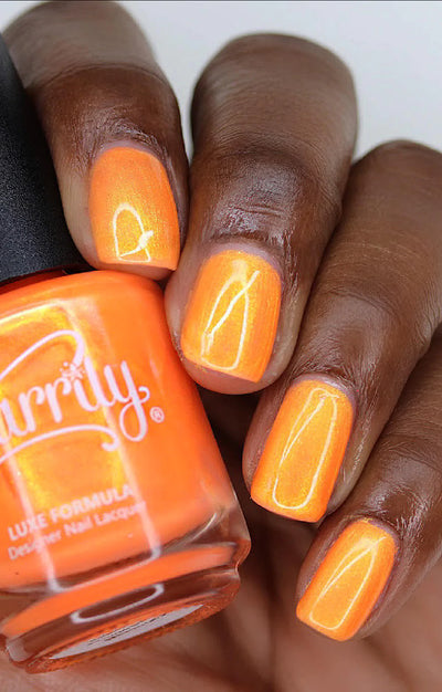 Peach Glow by Starrily, vivid orange base with green-to-gold color-shifting shimmer, bottle held in a rich hand