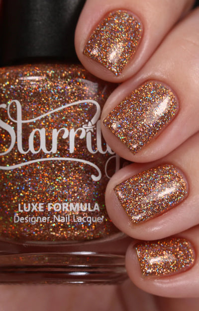 Penny by Starrily, golden copper micro holographic glitter with red-orange multidirectional rainbow flashes under studio lighting, on a light skin tone hand