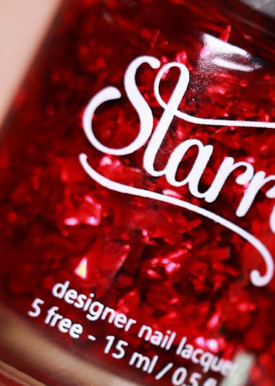 Rose Petals by Starrily, macro close-up of chunky petal-shaped ruby red metallic flakies with subtle iridescent edge shifts in a deep crimson base