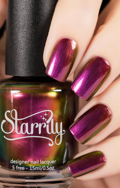 Love Affair by Starrily, gold-green multichrome shifting from magenta-pink to copper to olive green, bottle held in a light skin tone hand