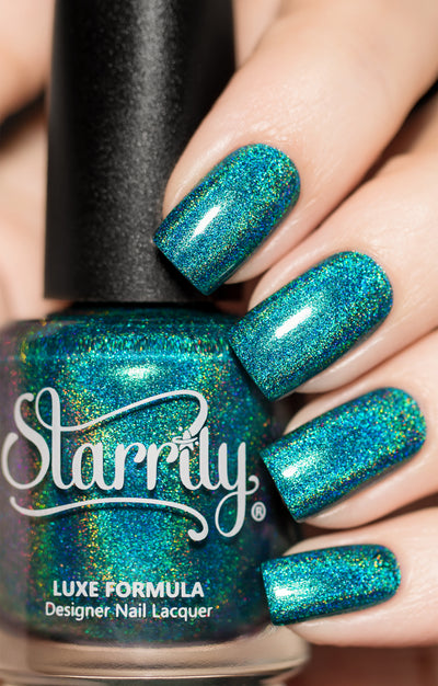 Tidal Wave by Starrily, teal-blue linear holographic with green, gold, and blue rainbow spectral scatter, bottle held in a light skin tone hand