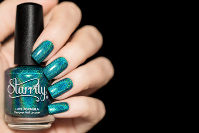 Tidal Wave by Starrily, teal-blue linear holographic with vivid rainbow scatter and gold holo sparkle, bottle held in a light skin tone hand