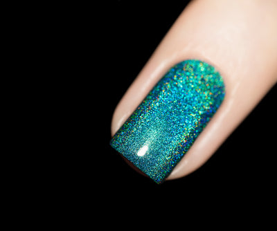 Tidal Wave by Starrily, teal linear holographic showing multispectral blue, green, and gold rainbow shift under direct flash, on a light skin tone hand