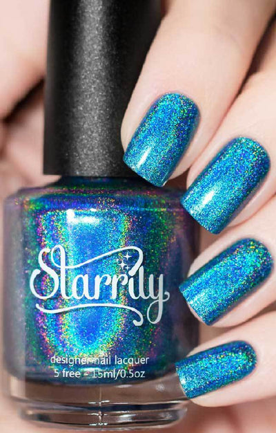 Cat Eyes by Starrily, medium blue holographic showing teal-green and violet prismatic dispersion, bottle held in a light skin tone hand