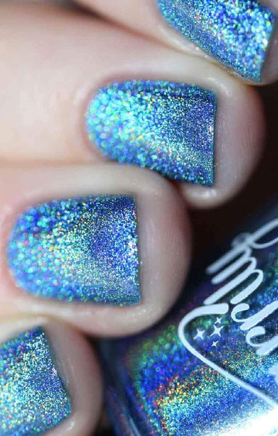 Cat Eyes by Starrily, medium blue linear holographic with cyan and green rainbow spectral scatter, on a light-medium skin tone hand