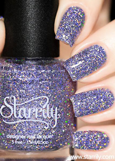 Damsel by Starrily, lilac-purple holographic glitter in clear base with rainbow flare, bottle held in a light hand