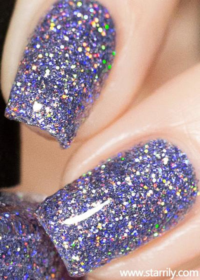 Damsel by Starrily, dense lilac-purple holographic glitter with rainbow prismatic flash in clear base, on a light skin tone hand