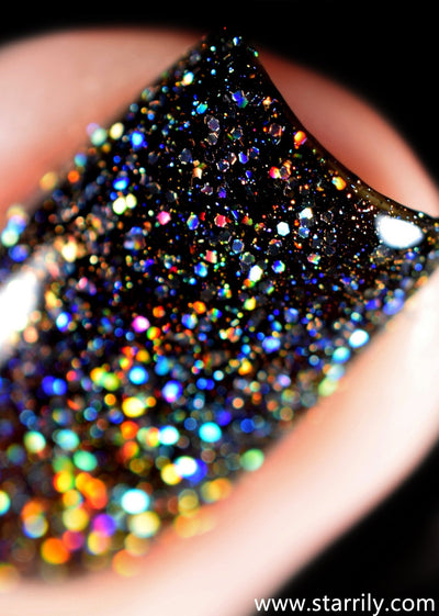 E=mc^2 by Starrily, macro close-up of dense mixed-size holo hex glitter exploding in blue, gold, and full-spectrum rainbow against a deep grey-black jelly base