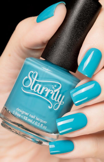 Private Island by Starrily, bright turquoise blue holographic glitter creme, opaque creme finish, bottle held in a light hand