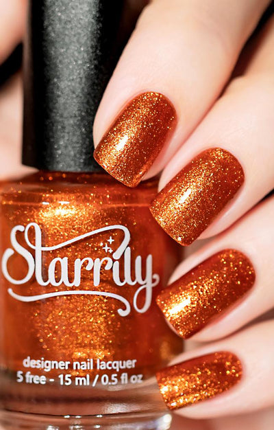 Sunlight (Orange Foil) by Starrily, burnt orange foil metallic showing warm golden-amber high-shine shimmer, bottle held in a light hand