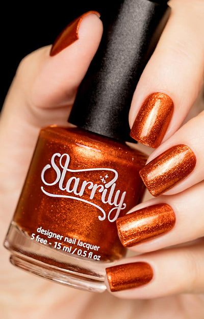 Sunlight (Orange Foil) by Starrily, burnt orange metallic foil with deep russet shadow and copper shimmer highlights, bottle held in a light hand