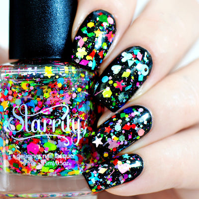 Toy Story by Starrily, dense mixed-shape glitter topper over black base with neon pink, cyan, yellow, and green stars, hearts, flowers, and hexagons, on a light skin tone hand