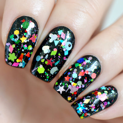 Toy Story by Starrily, 100-plus shaped glitter topper over black base with iridescent holographic pieces alongside neon red, yellow, and green stars, hearts, and flowers, on a light skin tone hand