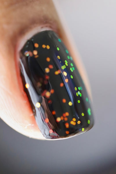 Firefly Jar (Limited Edition) by Starrily, clear flakie topper with dense orange-to-green-to-gold multichrome hex flakes, macro close-up showing full color-shift range over a near-black base